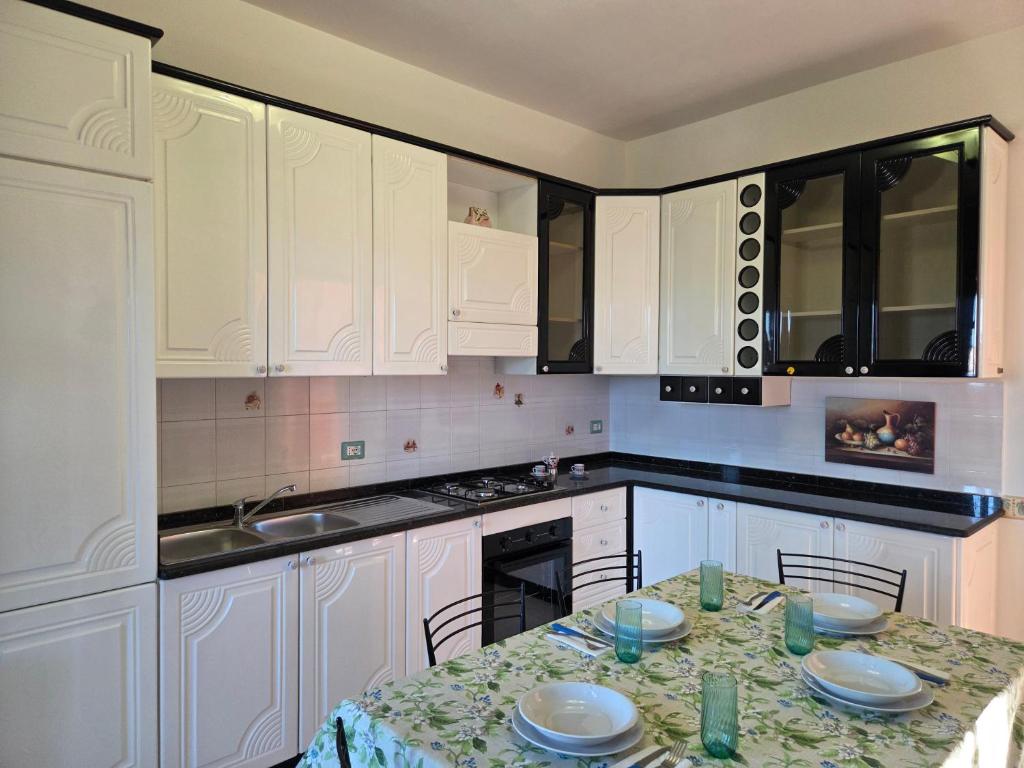 a kitchen with white cabinets and a table with chairs at Casa Dolce Armonia in Augusta