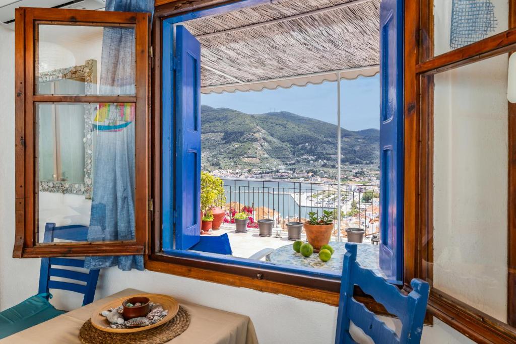 a room with a table and a window with a view at Stamatis Rooms in Skopelos Town
