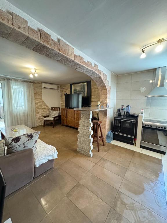 eine Küche und ein Wohnzimmer mit einer Steinwand in der Unterkunft Vila Aura in Podgorica