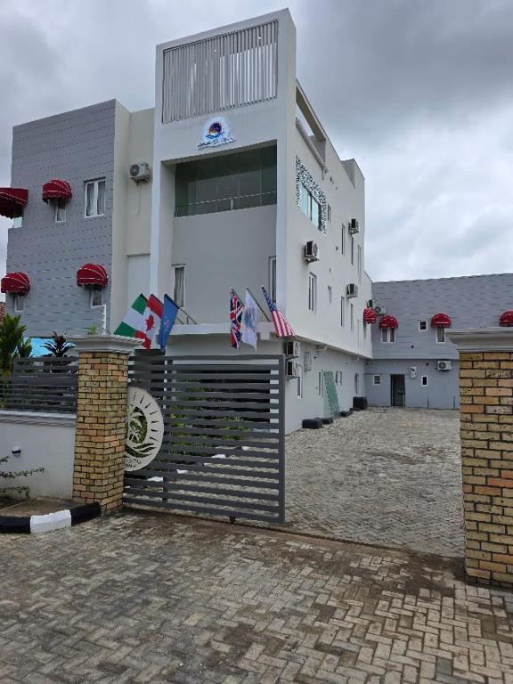a large white building with flags in front of it at Atlantis De Maria Hotels in Akure