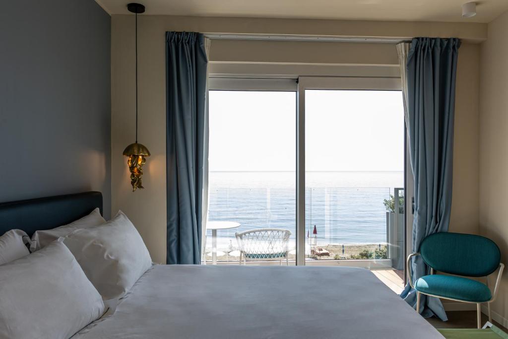 a hotel room with a bed and a large window at Acciuga Hotel in Laigueglia