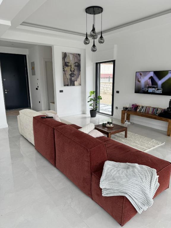 a living room with a red couch in the middle at Luxurious Villa in Cesme with private pool in Çeşme