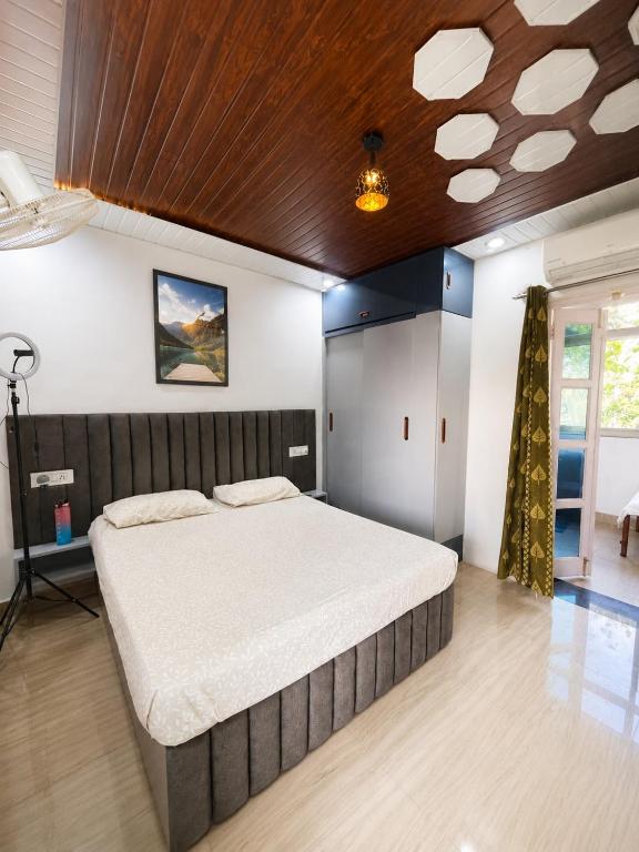 a bedroom with a large bed with a wooden ceiling at RK Homes in Delhi