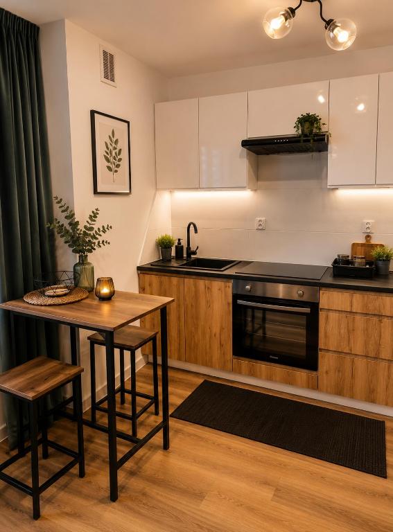a kitchen with a table and a stove at Classic Apartment in Konin