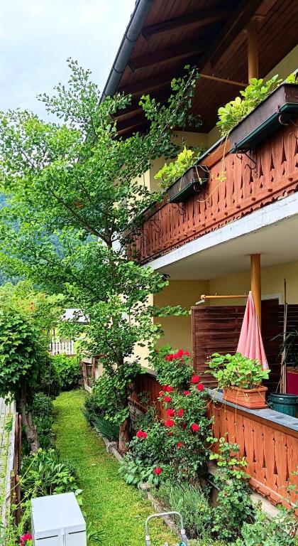 a garden outside a house with flowers and a umbrella at Ferienwohnung Eckschlager in Kössen