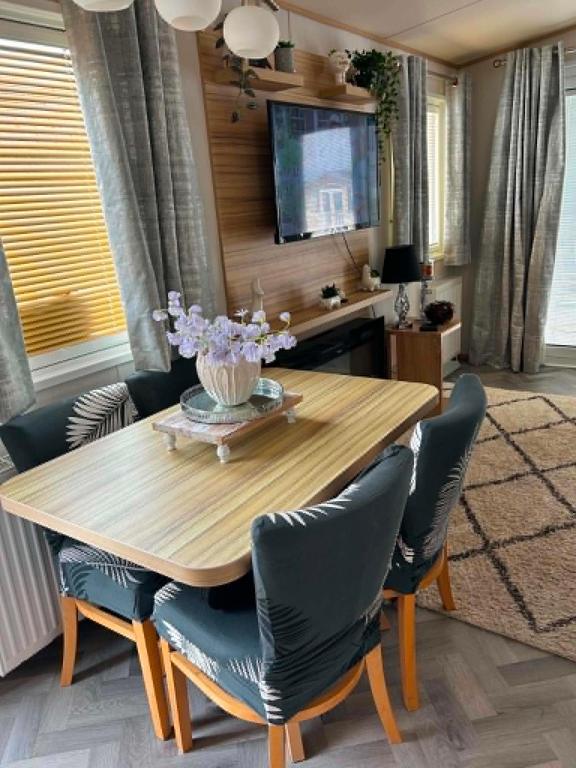 a dining room with a wooden table and chairs at The Pointon-Bordeaux Caravan Co in Rhyl