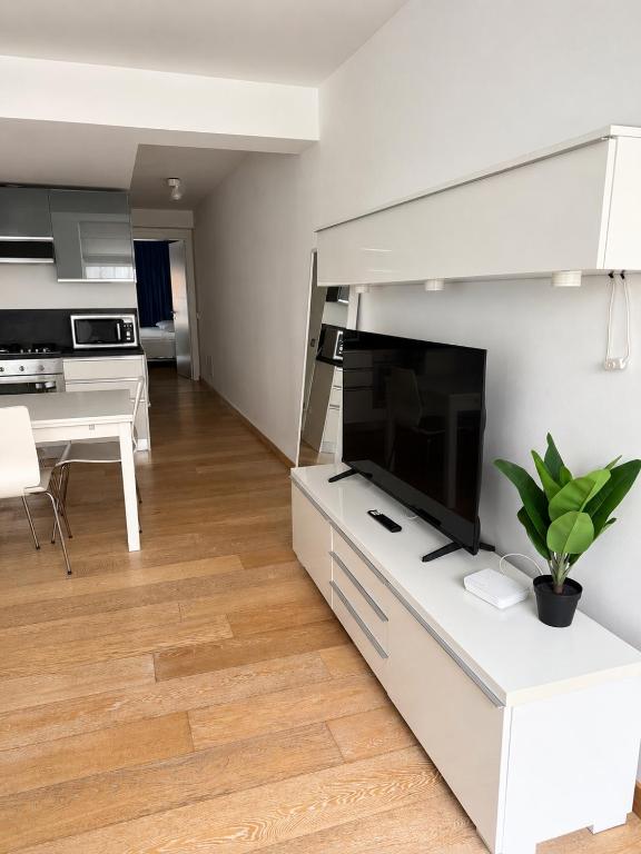 a white living room with a tv and a table at Domus Turrita in Bologna