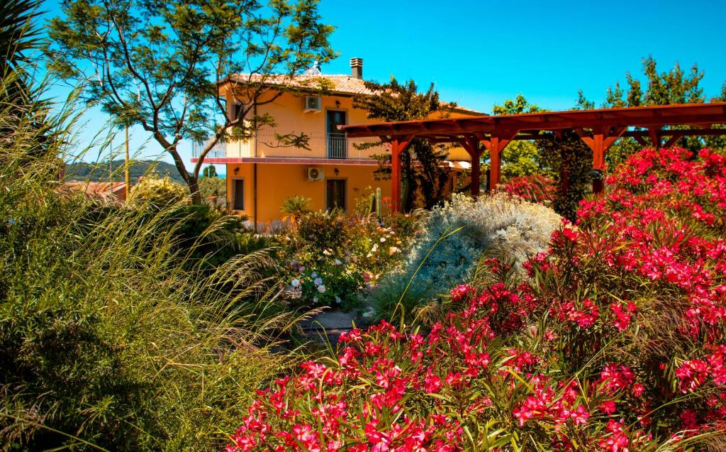 a garden with pink flowers in front of a house at Il Castello di Modolo in Modolo