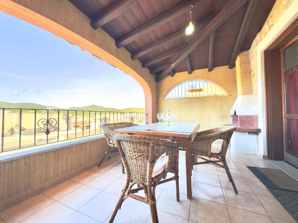 a dining room with a table and chairs on a balcony at Viola House in Villasimius