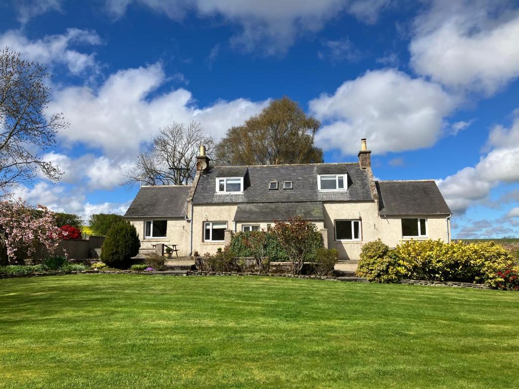 a large white house with a large yard at Westlea Cottage in Turriff