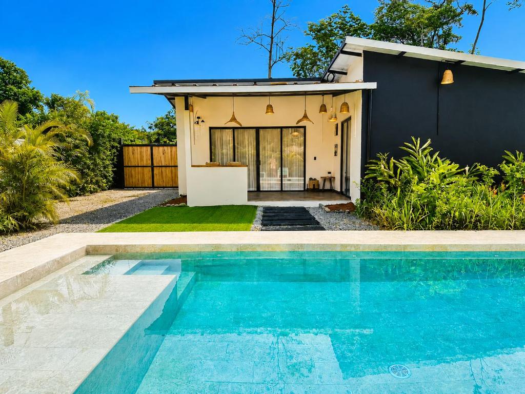 a house with a swimming pool in front of a house at Lalola de Puerto in Puerto Viejo