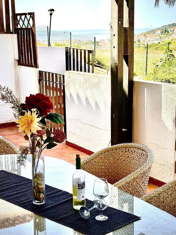 a table with a bottle of wine and two glasses at Le Casa del Sol de Marta in Manilva