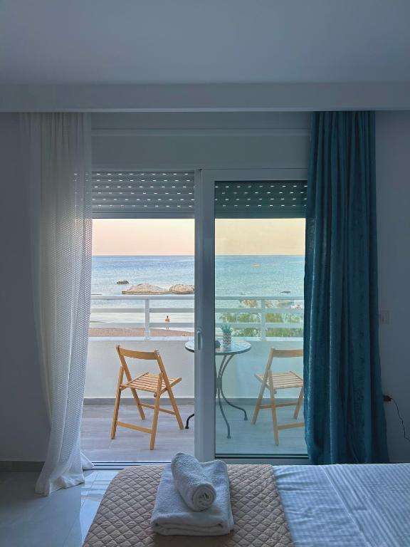 a bedroom with a bed and a view of the ocean at Chrisanthi Apartments in Archangelos