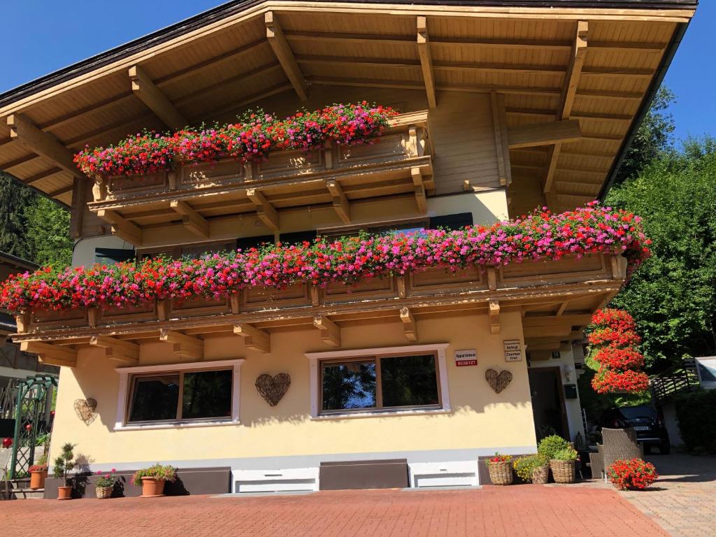 a building with a balcony with flowers on it at Pension Mirabelle in Ellmau