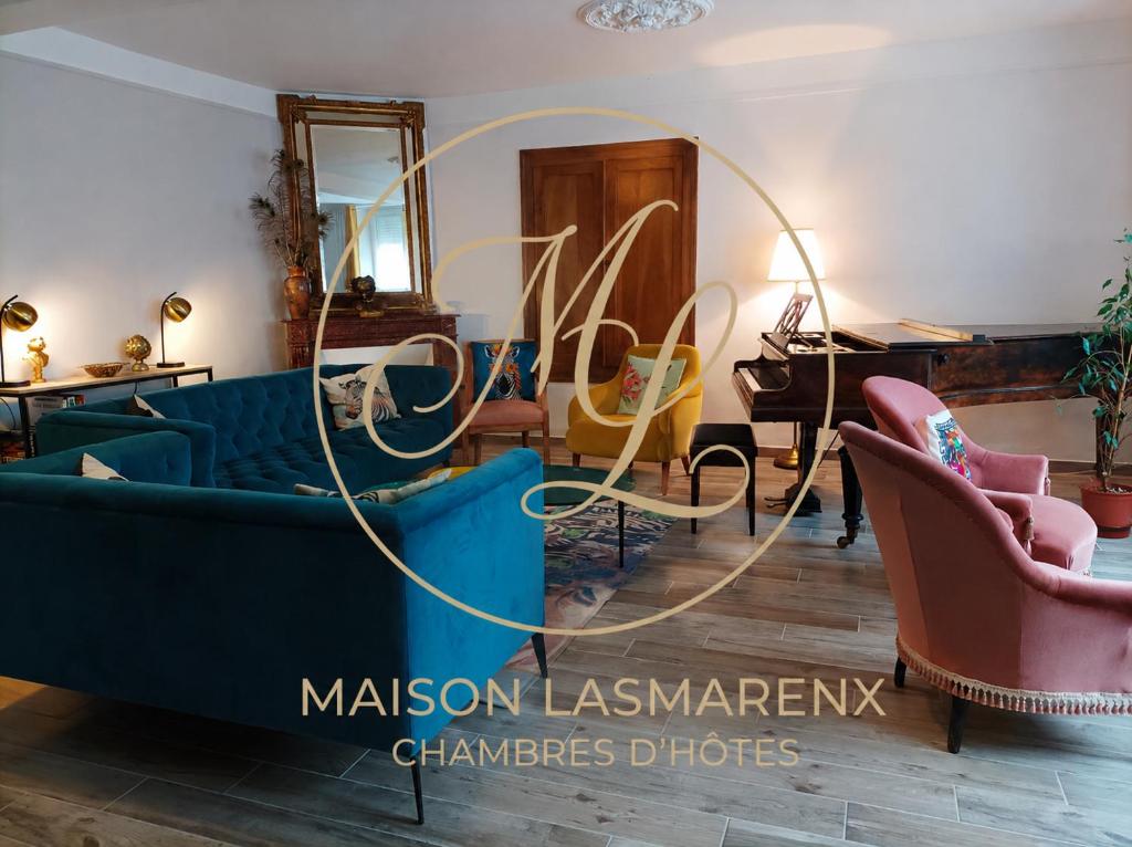 a living room with a blue couch and chairs at Maison Lasmarenx chambres d'hôtes in Jurançon