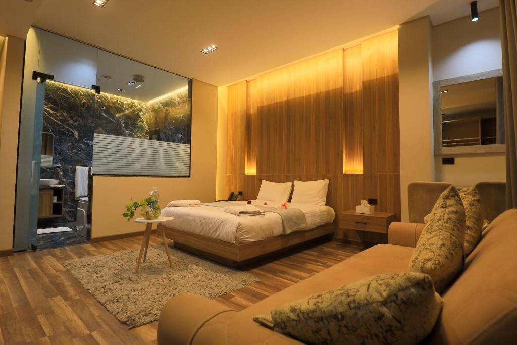 a hotel room with a bed and a couch at Farida Palace Hotel in Al Aqālitah