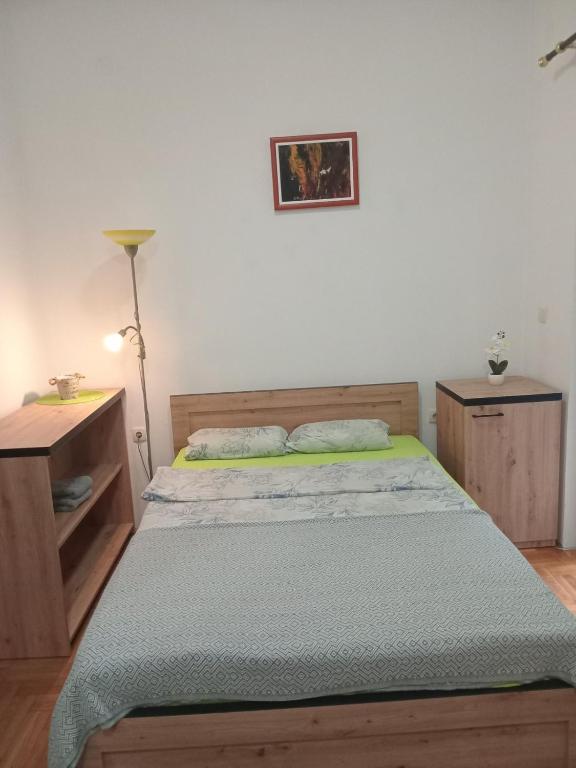 a bedroom with a bed and a desk and a lamp at Apartman studio DUE Apatin in Apatin