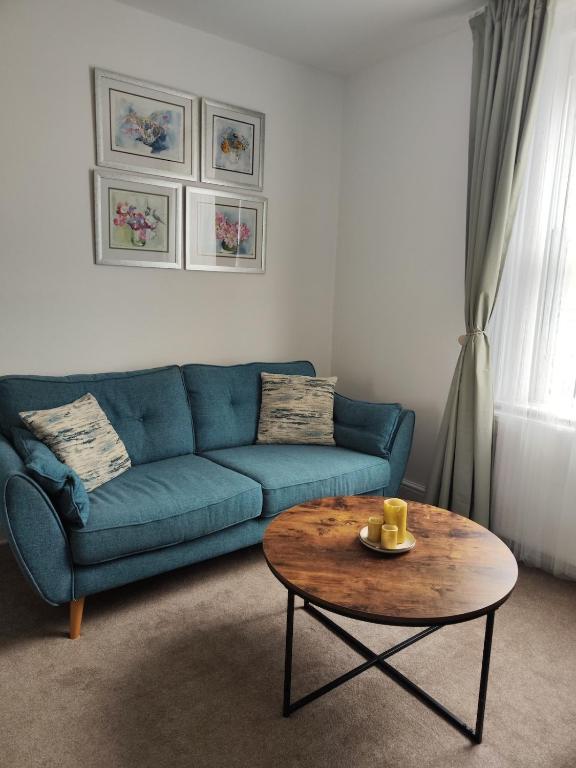 a living room with a blue couch and a coffee table at Sand Castle in Weymouth