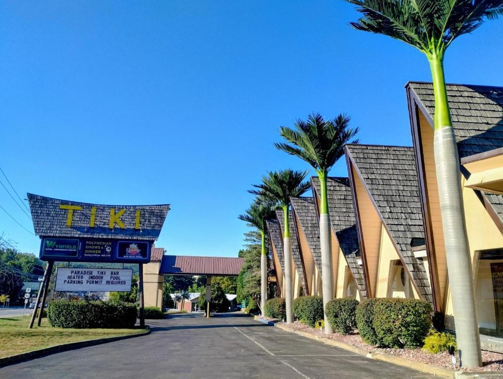 a street in front of a resort with palm trees at Tiki Resort - Lake George in Lake George