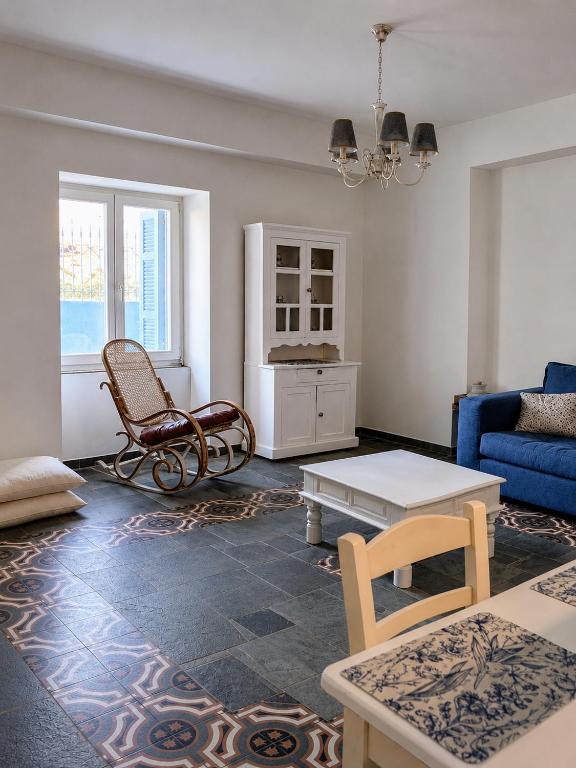 a living room with a blue couch and a table at Stellinas House 2 in Andros