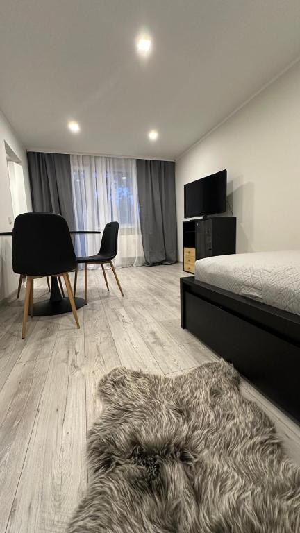 a bedroom with a bed and a table and a chair at Bright Apartment with Forest View Balcony in Naujoji Akmenė