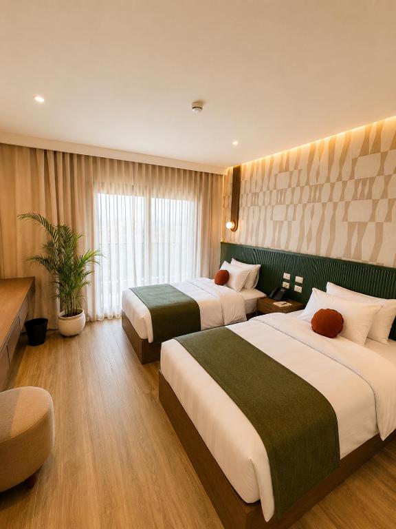 a hotel room with two beds and a couch at NOMA New Cairo in New cairo