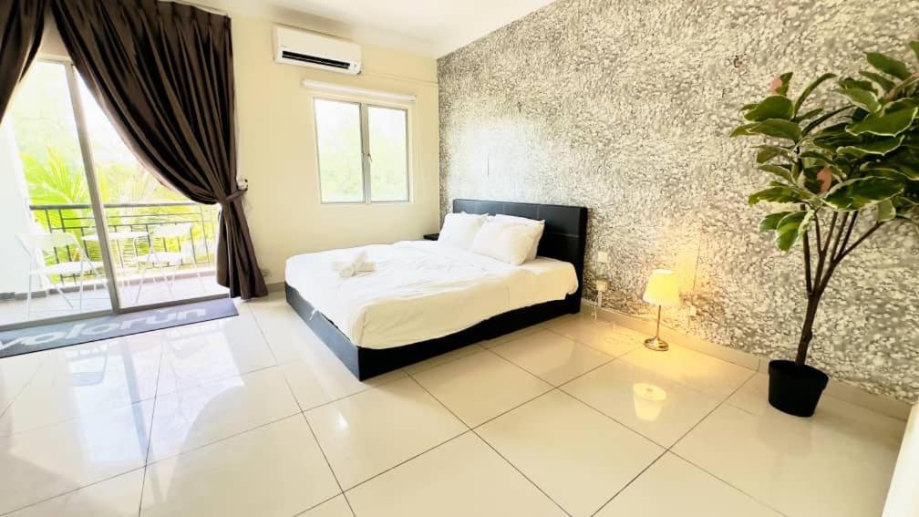 a bedroom with a bed and a potted plant at Desaru Coastline Cribs in Bandar Penawar