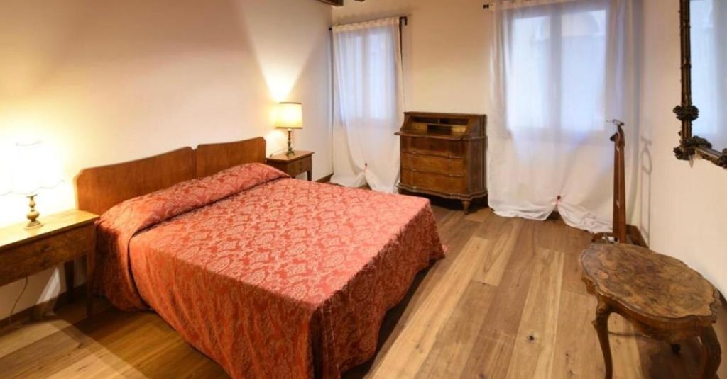 a bedroom with a bed and a dresser and a window at Mercerie e Capitello Apartments in Venice