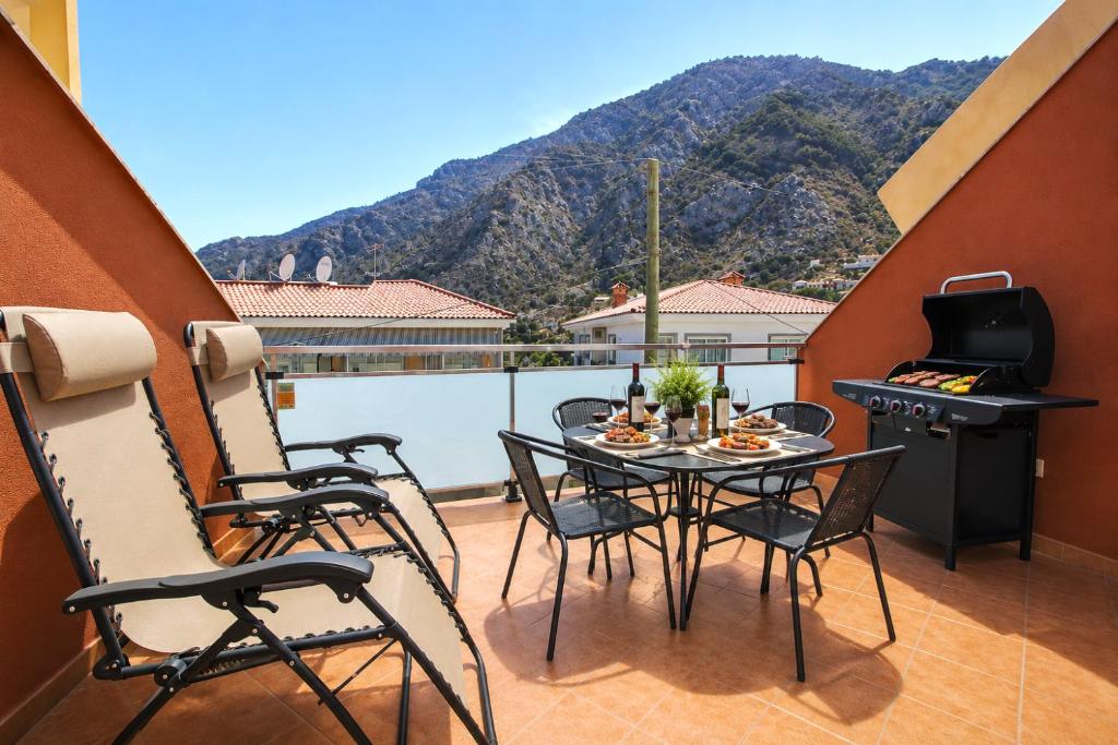 a balcony with a table and chairs and a grill at OPEN SKY VALLEY in Mogán