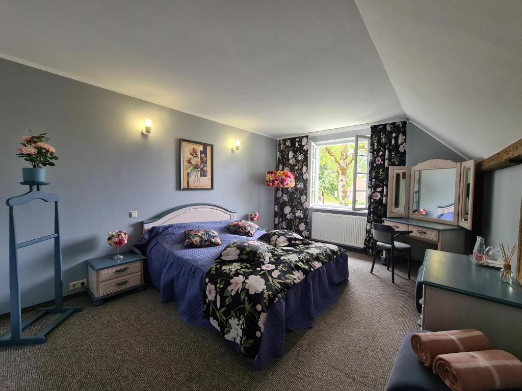 a bedroom with a bed and a desk and a window at Nicava in Nīca