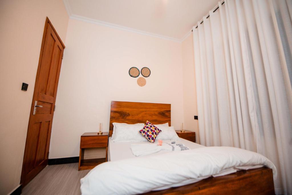 a bedroom with a bed and a pair of glasses on the wall at Heaven Hill Apartment in Arusha