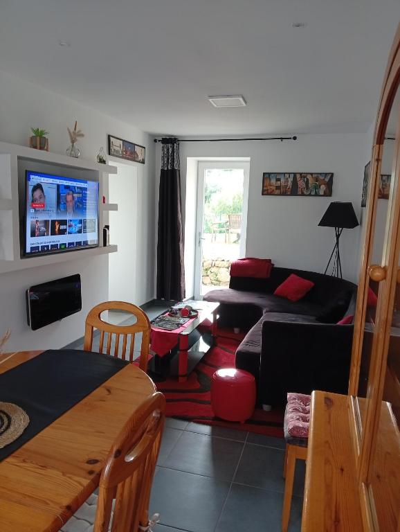 a living room with a couch and a tv at Tour de bridier in La Souterraine
