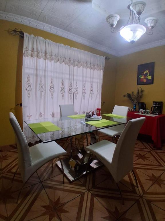 a dining room with a glass table and two chairs at Alexander b&b in Alajuela