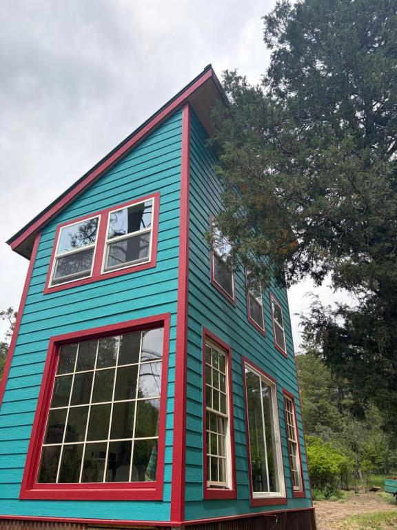 a blue and red house with windows at Pagosa Chi Camps in Pagosa Springs