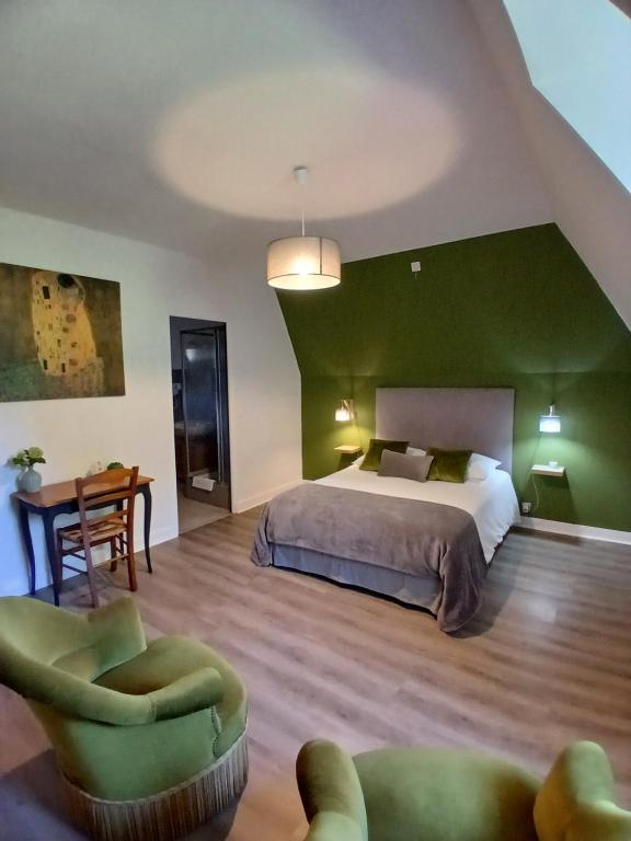 a bedroom with a bed and a chair and a table at Le Clos Gaillardou in La Roque-Gageac