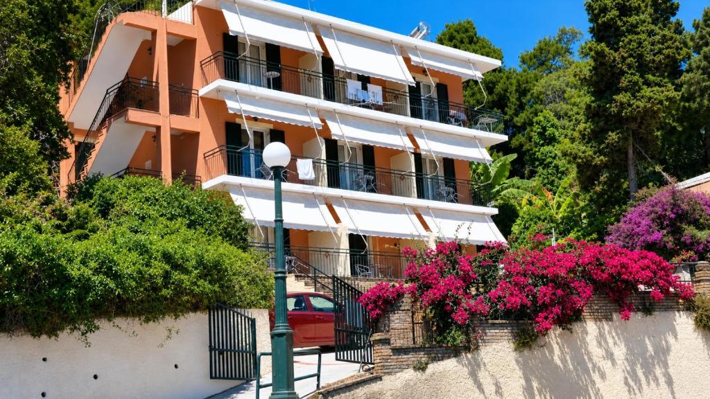 a building with pink flowers and a street light at Empress Corfu in Perama