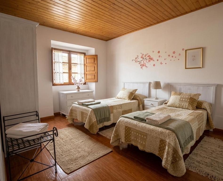 a bedroom with two beds and a wooden ceiling at Apartamentos El Cuetu in Llanes