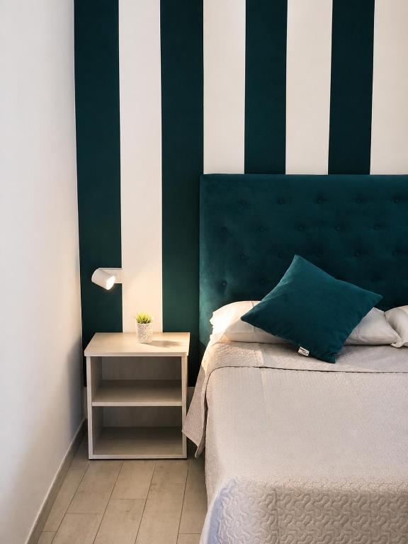a bedroom with a bed with a green and white wall at Affitti Brevi SCALA DEI TURCHI in Realmonte