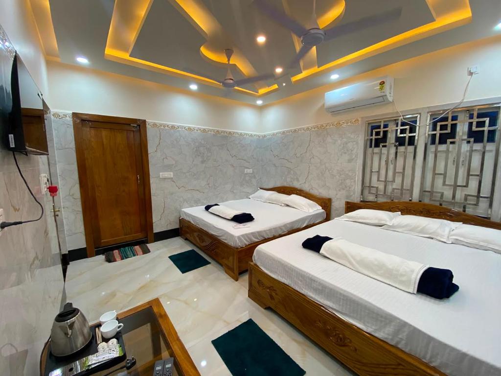 a bedroom with two beds and a tv in it at Jalangi Empire in mayapur