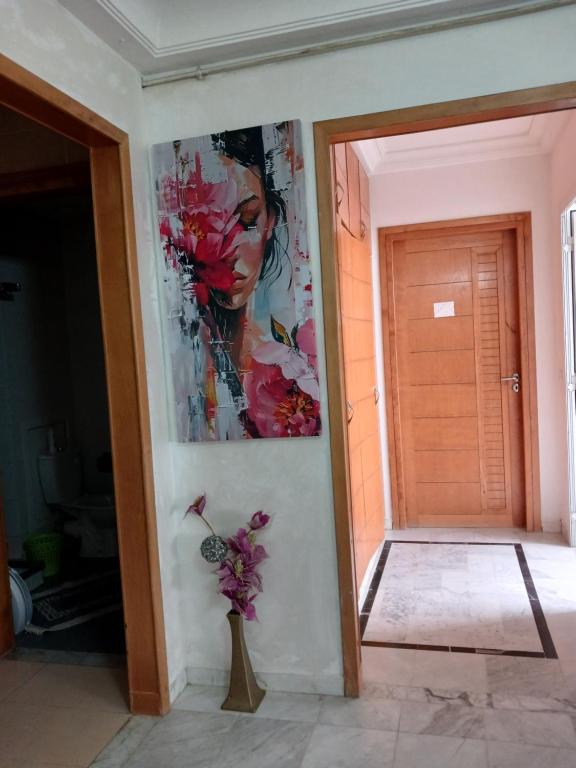 a painting of a woman on a wall next to a door at cozy appartement D6 in Hammamet