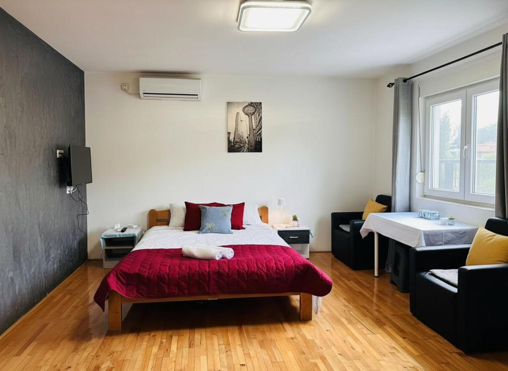 a bedroom with a bed with a red blanket at Alice's Home in Surčin