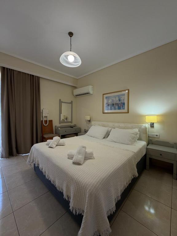 a bedroom with a large bed with two towels on it at Paradise Hotel in Kos
