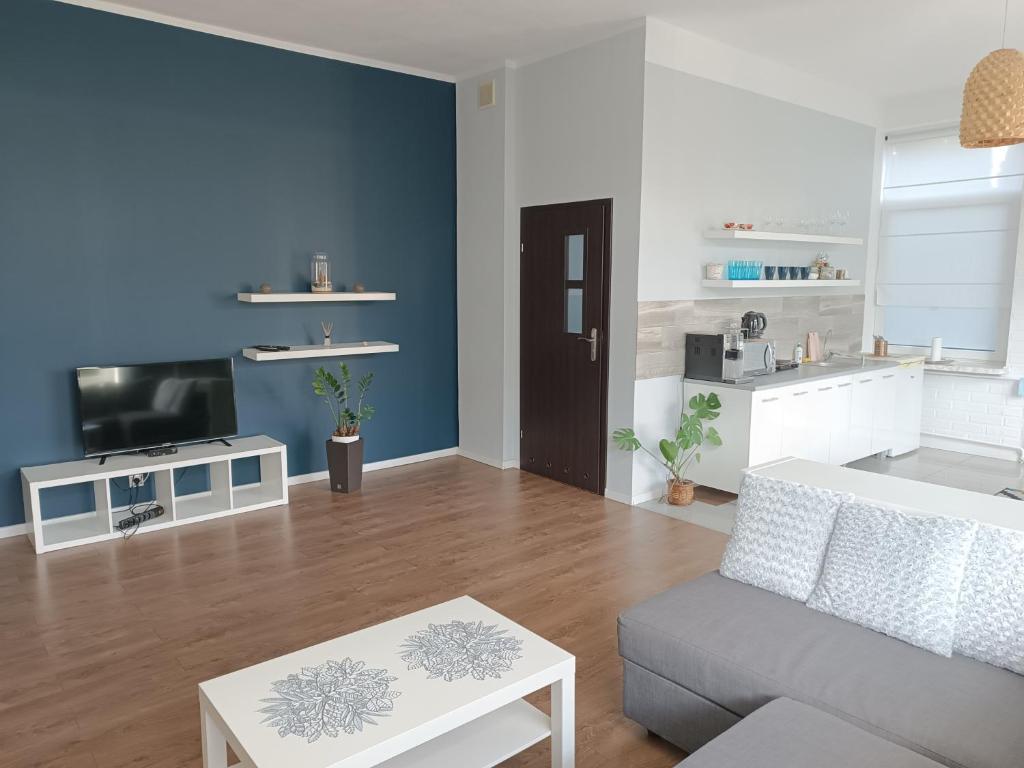 a living room with a couch and a tv at VillaMaria in Gdańsk