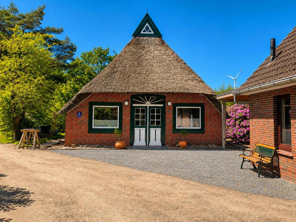 a brick building with a triangular roof with a door at Ferienhaus Heilhecker in Brake