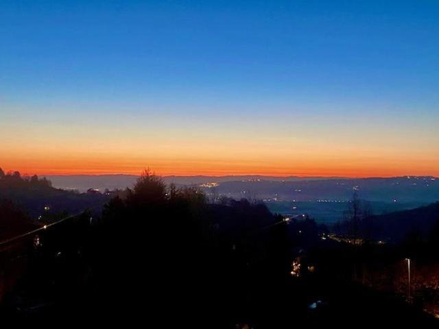 a view of the sunset from a hill with trees at Casa Negrita in Bra