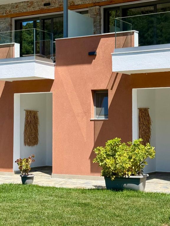 a red building with two plants in front of it at Skiathos Bliss Villa in Skiathos