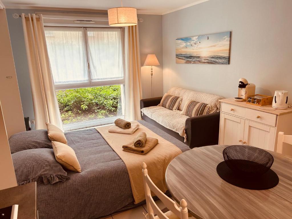 a bedroom with a bed and a couch and a window at Charmant studio proche gare - parking privatif individuel clos in Arras