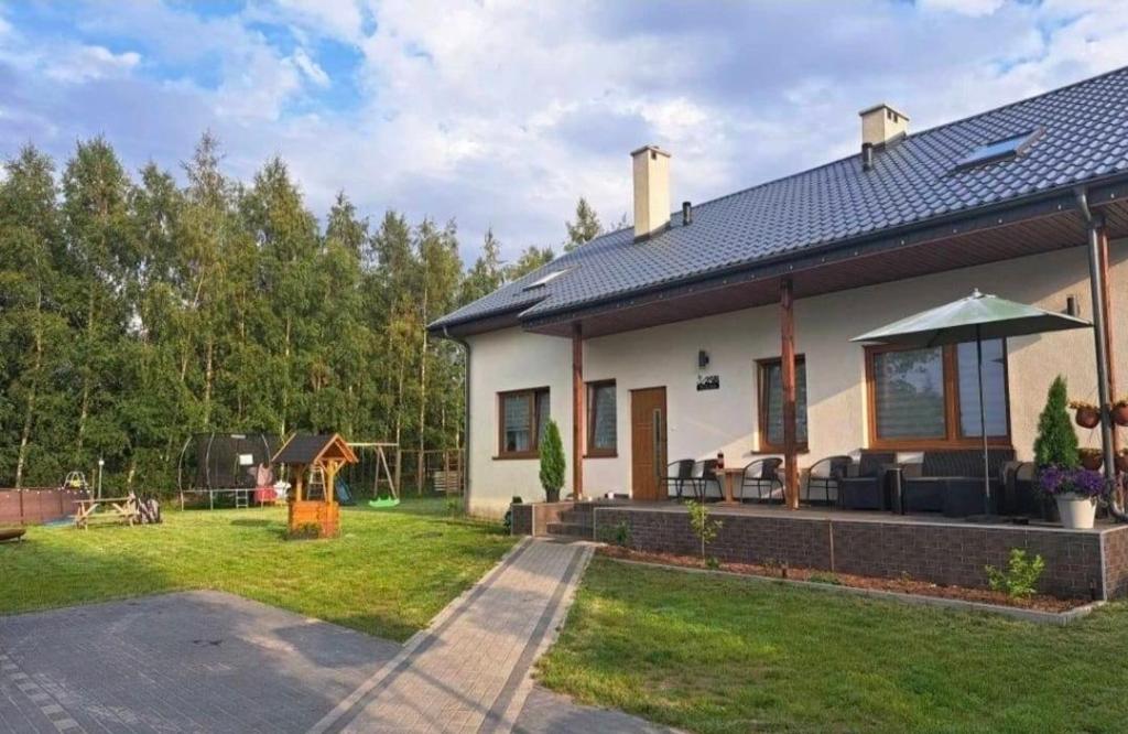 a house with a patio and a yard at Windrose in Ustronie Morskie
