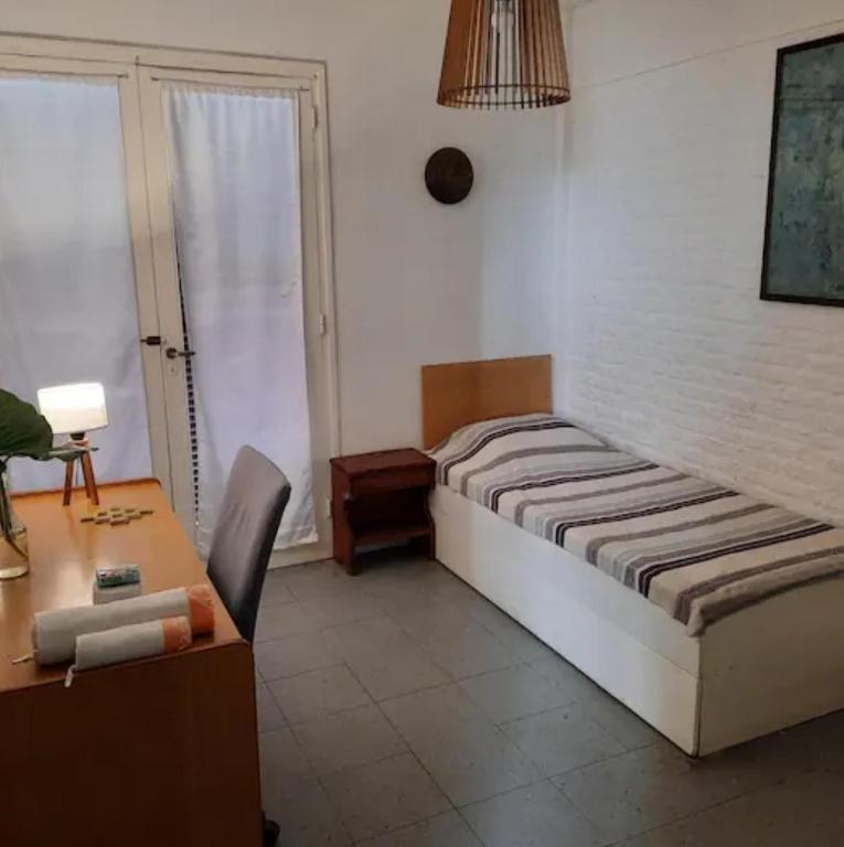 a bedroom with a bed and a table and a desk at LodelaAbuela 2 in Ciudadela