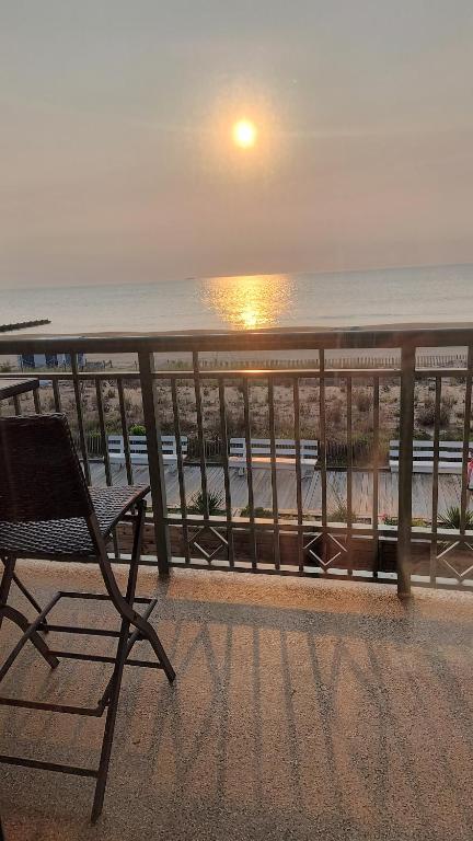 a chair sitting on a balcony looking out at the ocean at Edgewater House in Rehoboth Beach